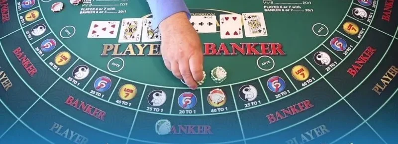 Dealer đặt chip trên bàn baccarat online nỉ xanh, hai tay bài Player và Banker lật ngửa, các ô cửa phụ ghi 40 TO 1