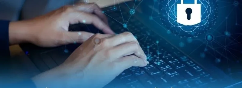 Hai bàn tay gõ bàn phím laptop với đường mạng xanh và biểu tượng ổ khóa trắng, minh họa quyền riêng tư khi trực tuyến